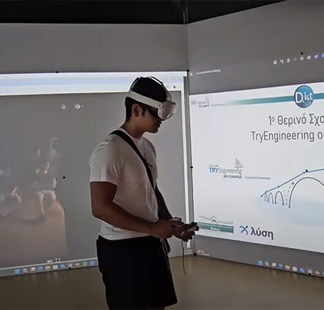 Student wearing VR headset in front of classroom with projector displaying Greek technology